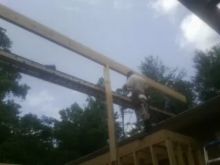 Carpenter setting a ridge beam over a new addition frame — Ice Dam Removal by Roofing Brothers in Riegelsville
