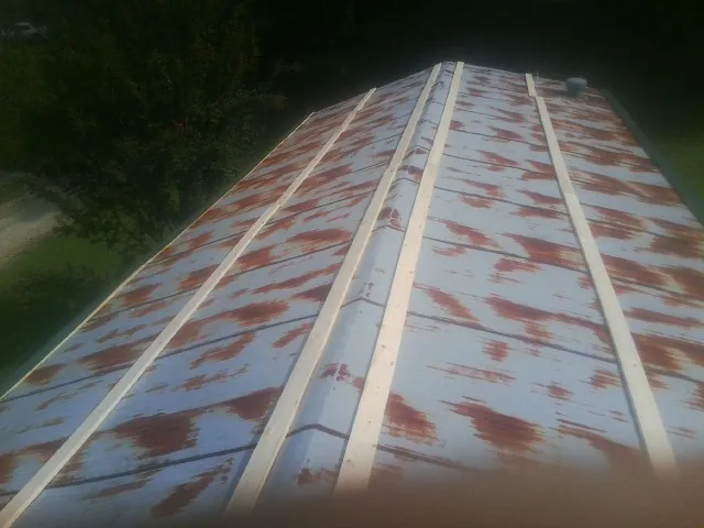 Rusted metal roof panels with new wood purlins before replacement — Storm Damage Roof Repair in Riegelsville by Roofing Brothers
