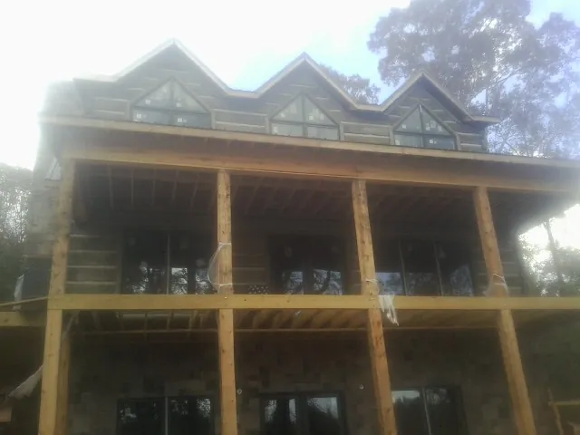 Dormers and porch framing on a large log home under construction — Roof Coating work by our crew in Riegelsville