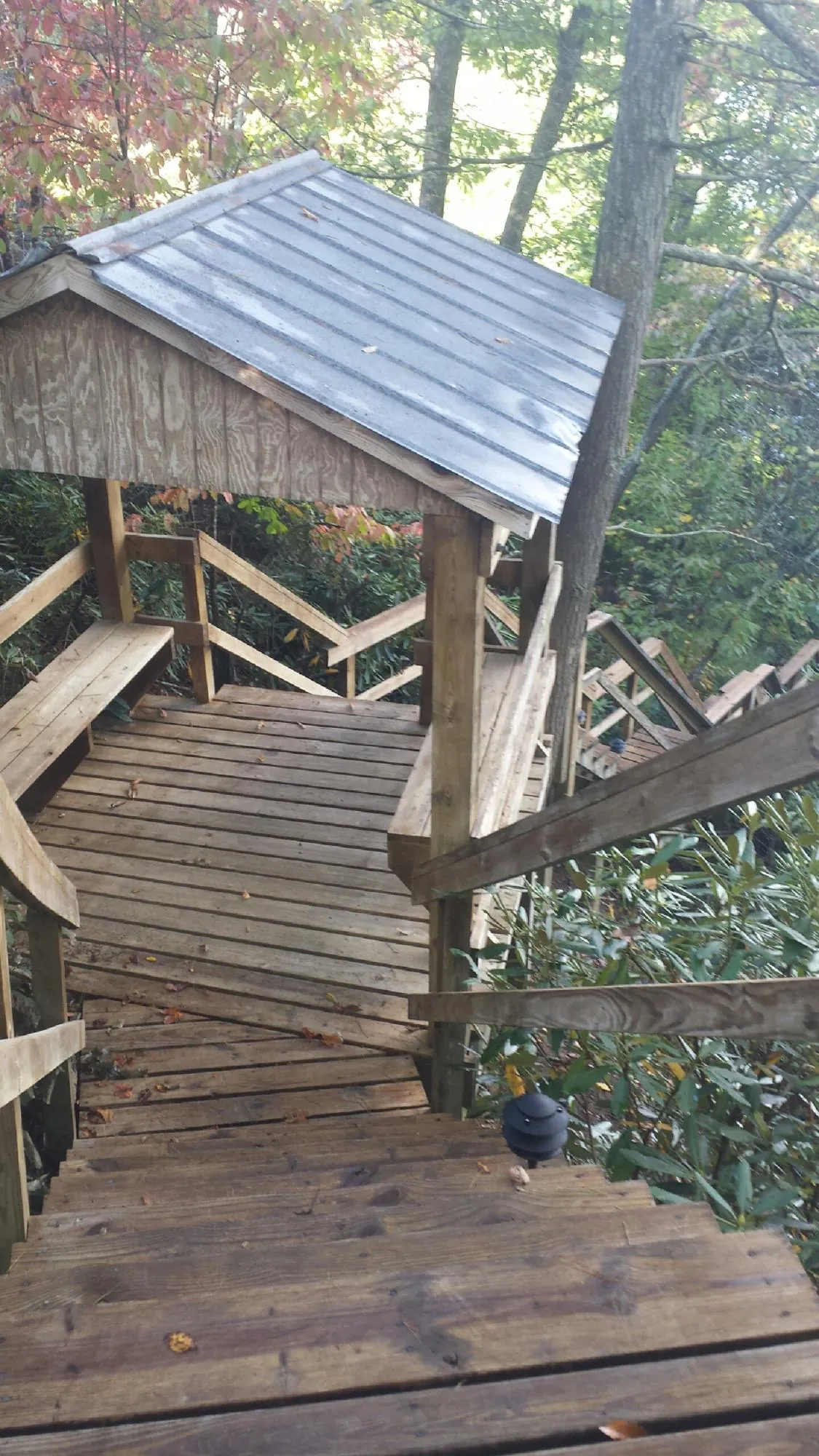 Metal roofed shelter over wooden steps on a wooded walkway — Skylight Repair & Installation work by our crew in Riegelsville
