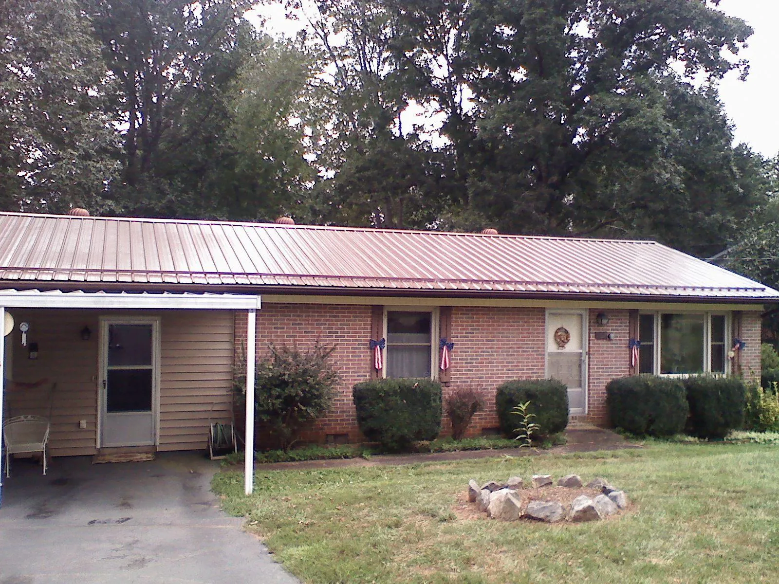Bronze metal roof and carport on a brick ranch home — Roof Repair work by our crew in Riegelsville